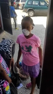 A girl in Haiti wearing a mask