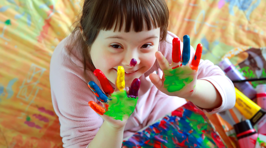 Little girl with down syndrome finger painting