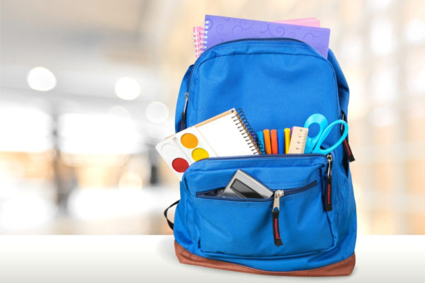 Blue backpack with school supplies coming out